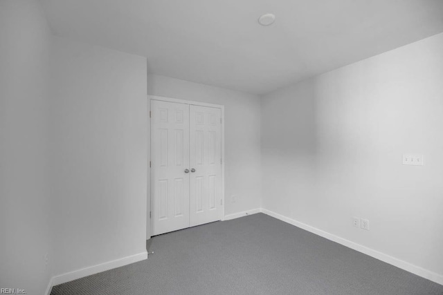 unfurnished room with dark colored carpet