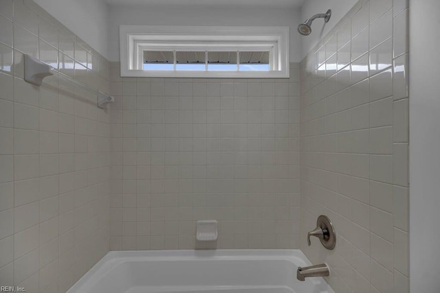 bathroom featuring tiled shower / bath combo and a healthy amount of sunlight