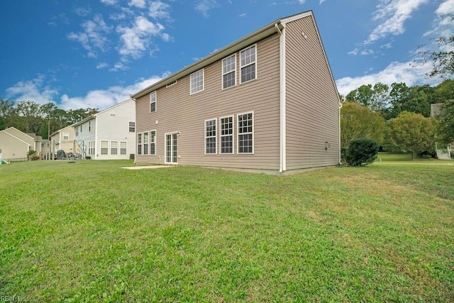 rear view of house featuring a yard