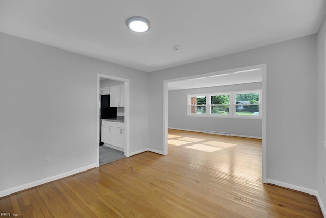 empty room with light hardwood / wood-style flooring