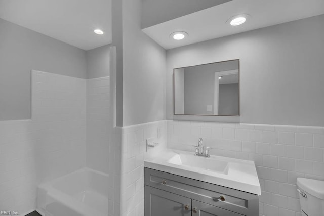 full bathroom featuring shower / bathing tub combination, vanity, tile walls, and toilet