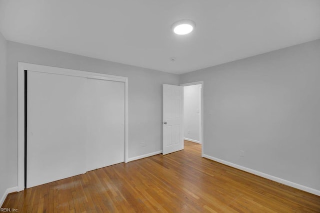 unfurnished bedroom with wood-type flooring and a closet