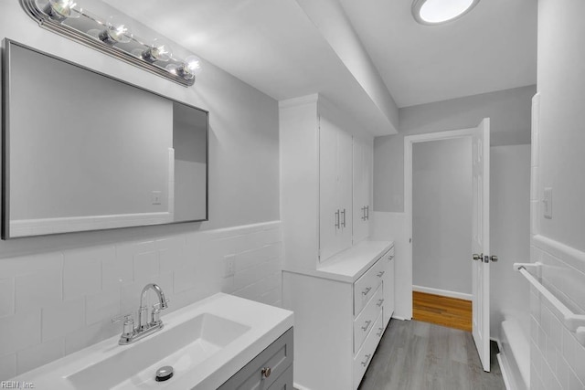 bathroom featuring hardwood / wood-style floors, vanity, and tile walls