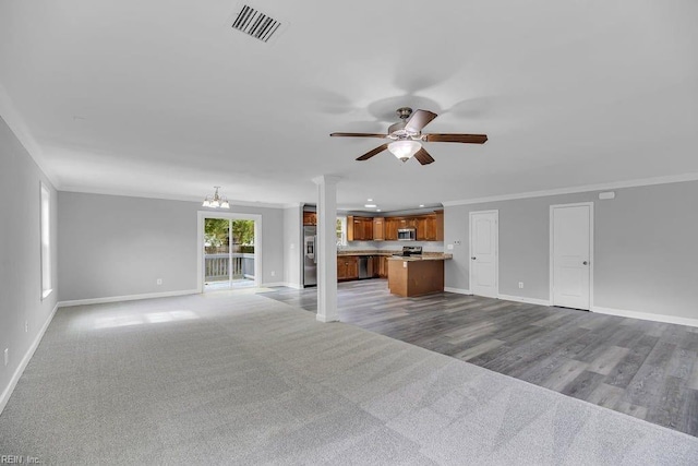 unfurnished living room with ceiling fan with notable chandelier and crown molding