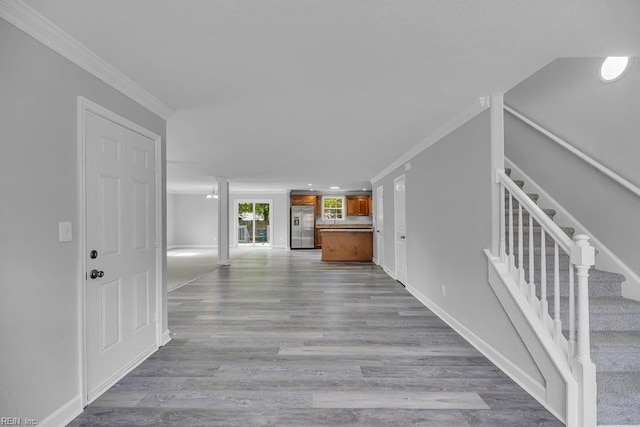 corridor with light hardwood / wood-style floors and crown molding