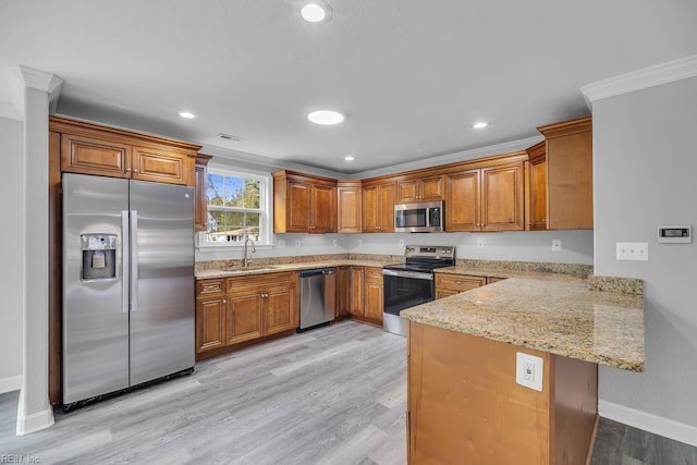 kitchen with kitchen peninsula, appliances with stainless steel finishes, ornamental molding, sink, and light hardwood / wood-style floors