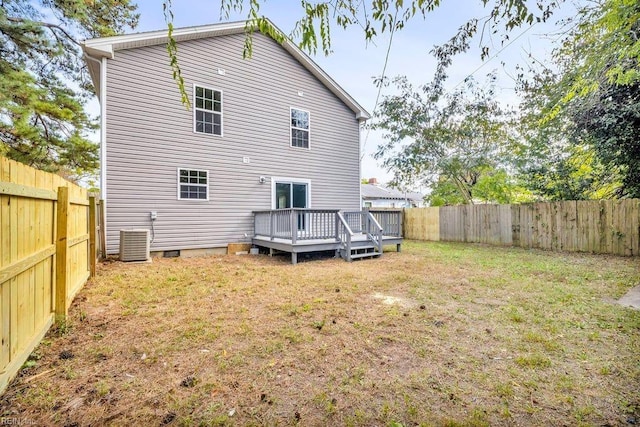 back of property with a lawn, a deck, and central AC