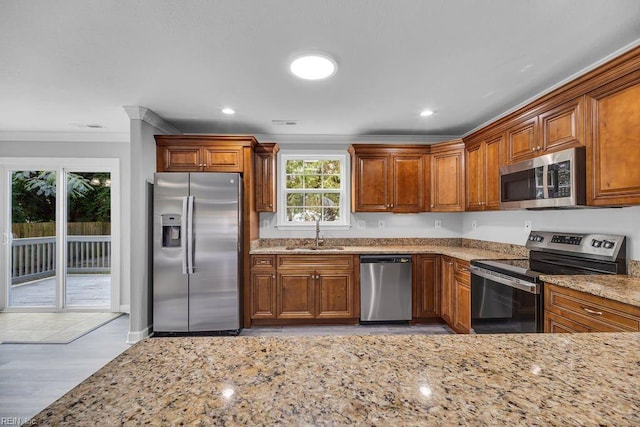 kitchen with crown molding, sink, appliances with stainless steel finishes, light hardwood / wood-style floors, and light stone counters