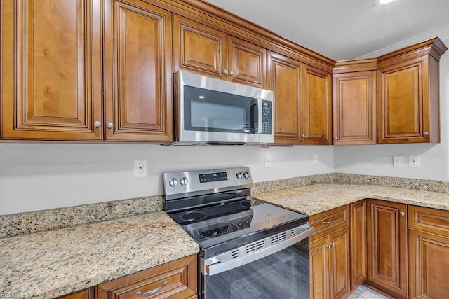 kitchen featuring light stone counters and stainless steel appliances