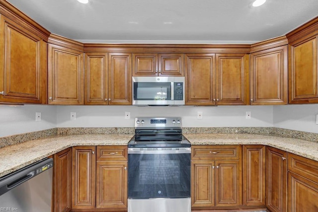 kitchen with light stone countertops and appliances with stainless steel finishes