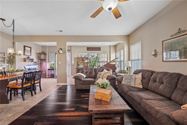 living room with wood-type flooring and ceiling fan with notable chandelier