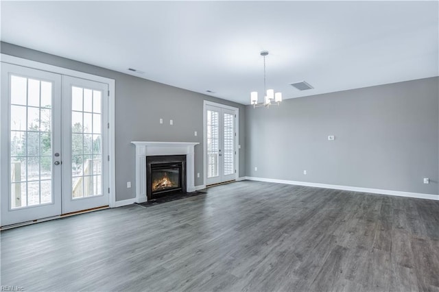 unfurnished living room featuring dark hardwood / wood-style flooring, a wealth of natural light, and french doors