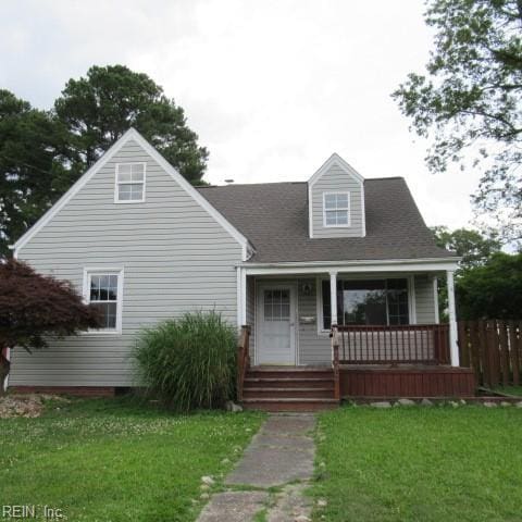 new england style home featuring a porch and a front lawn