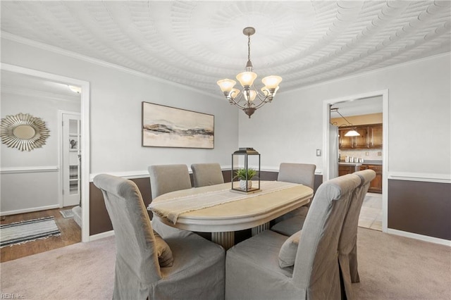 dining area with a chandelier, light colored carpet, and ornamental molding