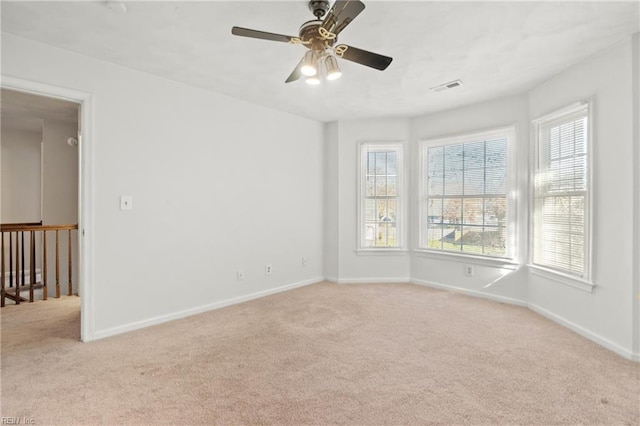 spare room featuring light carpet and ceiling fan