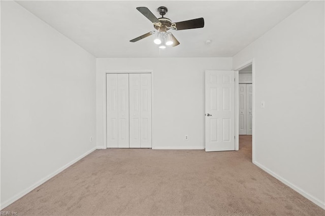 unfurnished bedroom featuring ceiling fan, light carpet, and a closet