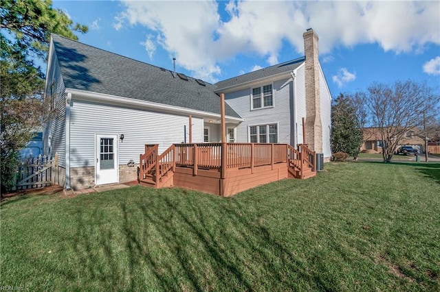 rear view of property featuring a deck and a lawn