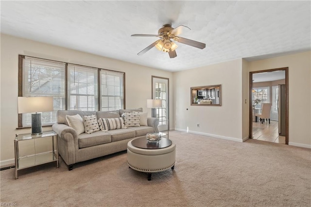 carpeted living room with ceiling fan and a wealth of natural light