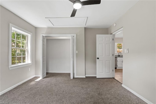 unfurnished bedroom featuring ceiling fan, a closet, carpet, and sink