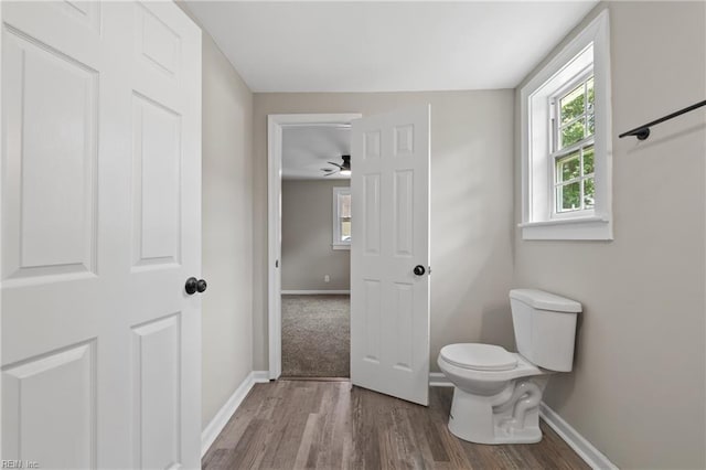 bathroom with hardwood / wood-style floors, toilet, and ceiling fan