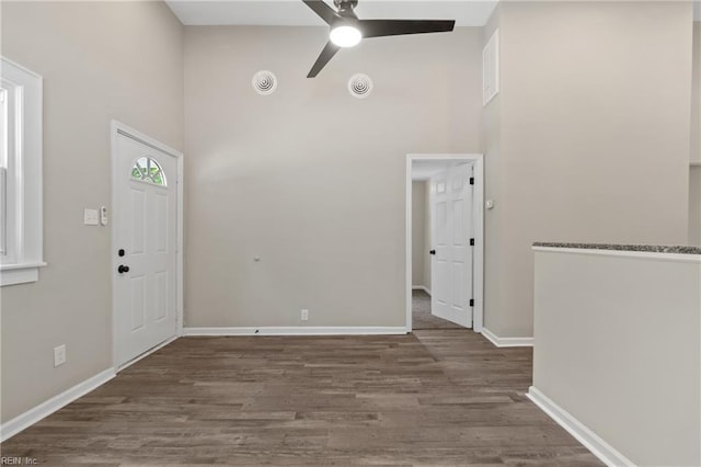 entrance foyer with ceiling fan, dark hardwood / wood-style floors, and a high ceiling