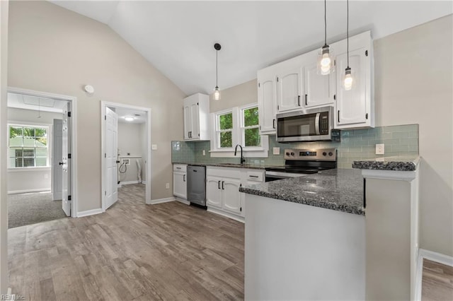 kitchen with backsplash, sink, white cabinetry, kitchen peninsula, and stainless steel appliances