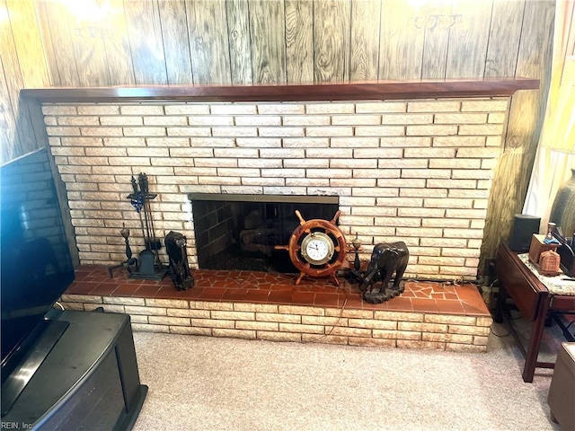 interior details featuring wood walls, carpet floors, and a brick fireplace