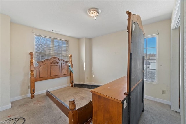 carpeted bedroom featuring multiple windows