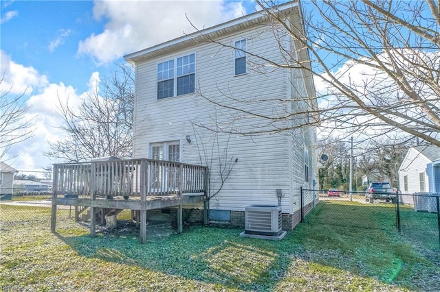 rear view of property featuring central air condition unit, a wooden deck, and a yard