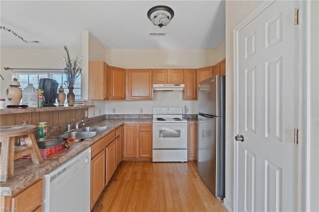 kitchen featuring light stone counters, sink, light hardwood / wood-style floors, and white appliances