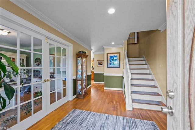 entrance foyer featuring french doors, wood-type flooring, and ornamental molding