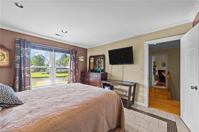 bedroom with light tile patterned floors and crown molding