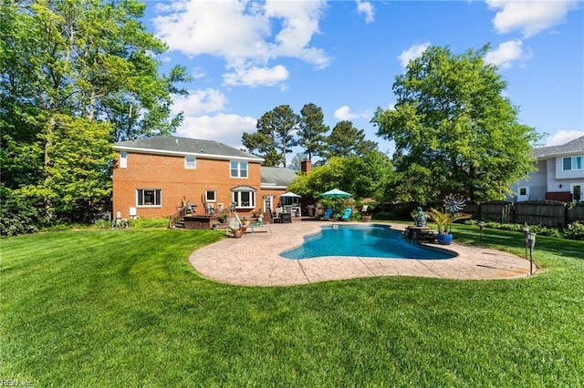 view of pool with a lawn and a patio