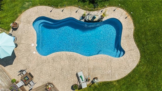 view of swimming pool with a yard