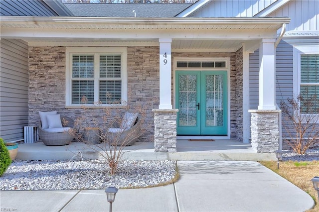 doorway to property featuring covered porch and french doors