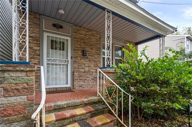 view of exterior entry featuring covered porch