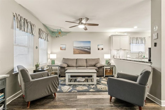 living room featuring dark hardwood / wood-style floors, ceiling fan, and sink