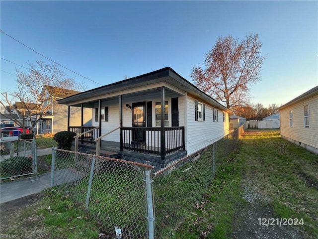 view of front of house with covered porch and a front lawn