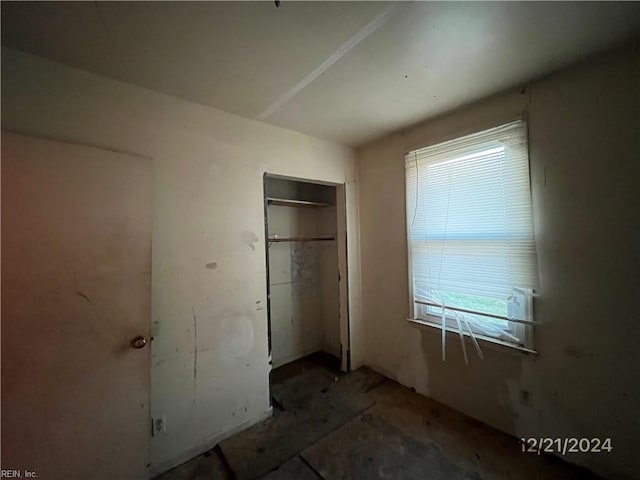 unfurnished bedroom featuring multiple windows and a closet