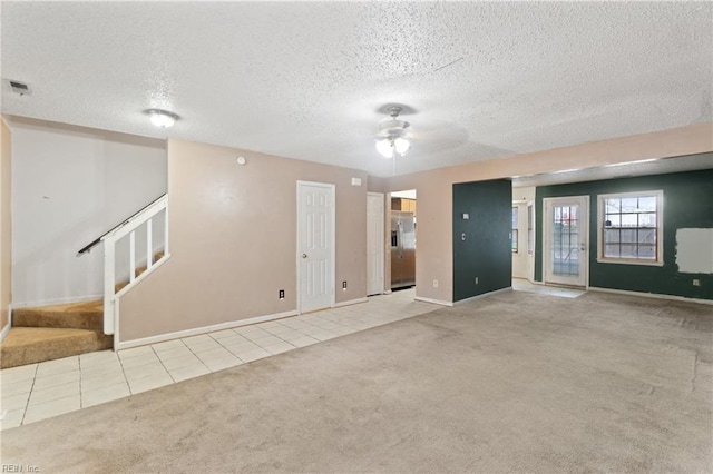 spare room with light carpet, ceiling fan, and a textured ceiling