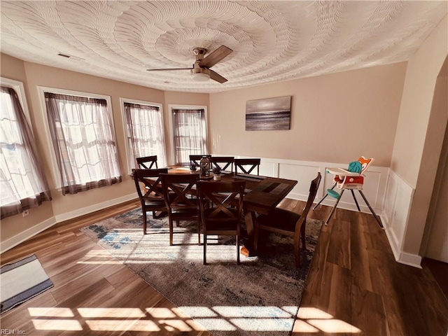 dining space with hardwood / wood-style flooring and ceiling fan