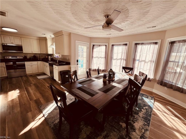 dining room with ceiling fan, sink, and dark wood-type flooring