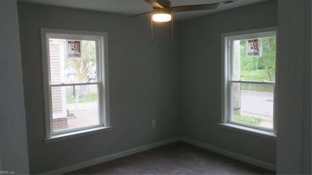 carpeted empty room with ceiling fan and a wealth of natural light