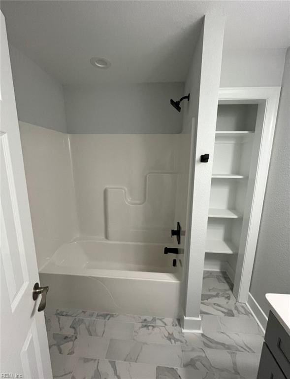 bathroom featuring bathtub / shower combination, vanity, and built in features