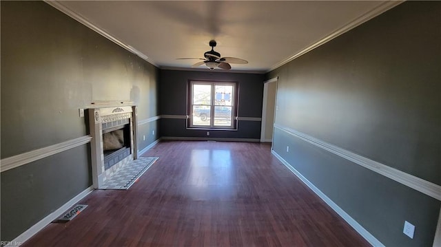 unfurnished living room featuring a tiled fireplace, ceiling fan, dark hardwood / wood-style flooring, and ornamental molding