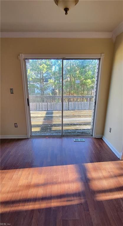 empty room with dark wood-type flooring and ornamental molding