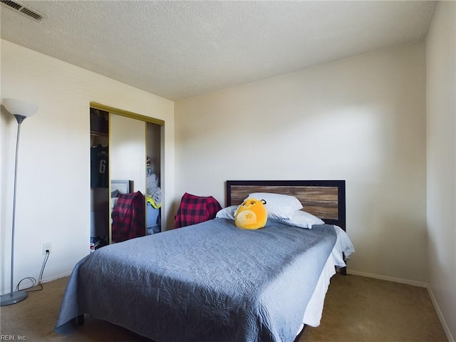 bedroom with a textured ceiling, a closet, and carpet flooring