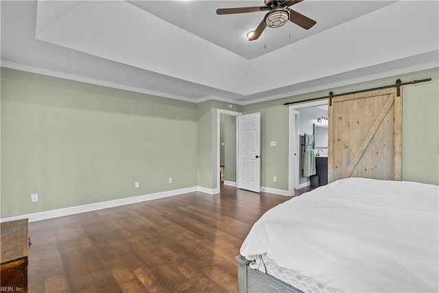 bedroom featuring ceiling fan, a barn door, a raised ceiling, and dark hardwood / wood-style floors