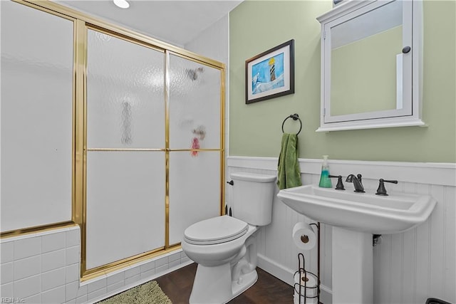 bathroom featuring wood-type flooring, toilet, an enclosed shower, and sink