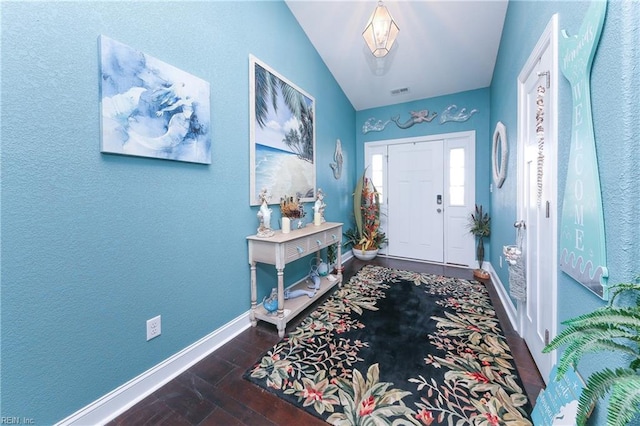 entryway with visible vents, baseboards, lofted ceiling, and wood finished floors